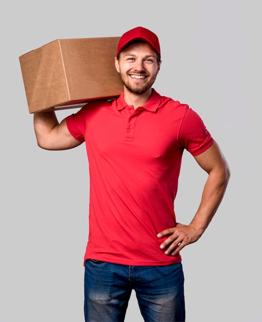 Free photo delivery man with package on shoulder