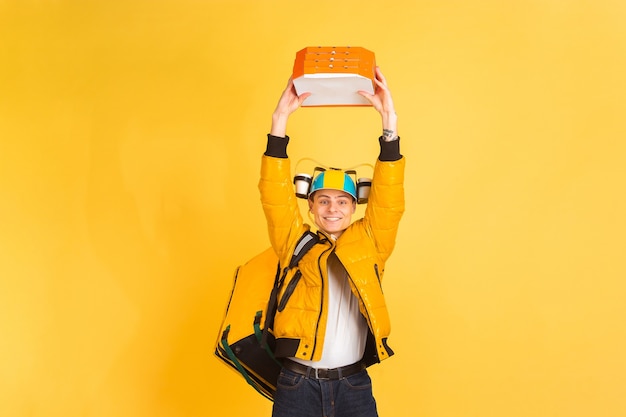 Free Photo delivery service concept. man delivers food and shopping bags isolated on yellow wall