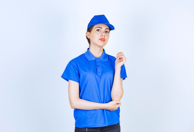 Free Photo delivery woman employee in blue uniform standing and posing.