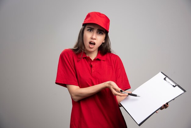 Delivery woman in red uniform having troubles. 