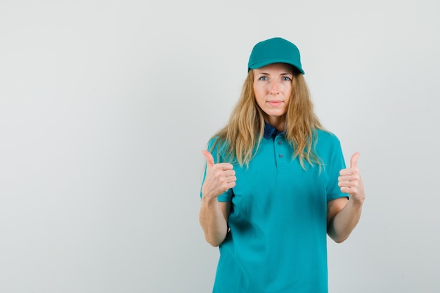 Free Photo delivery woman showing double thumbs up in t-shirt, cap and looking pleased. 