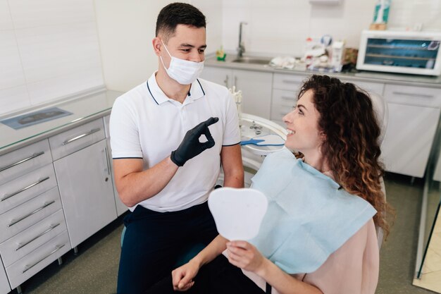 Dentist approving patient smile