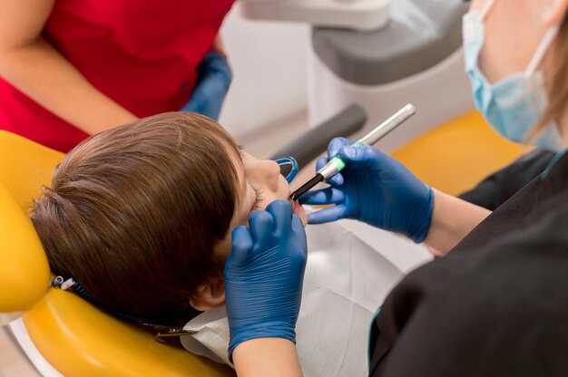 Dentist cleaning child's teeth