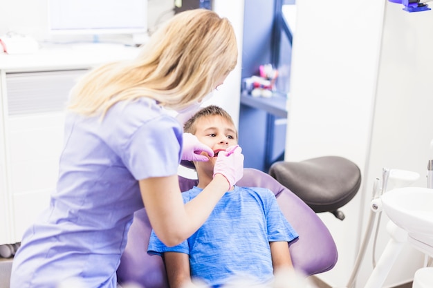 Dentist doing dental treatment of a boy in clinic