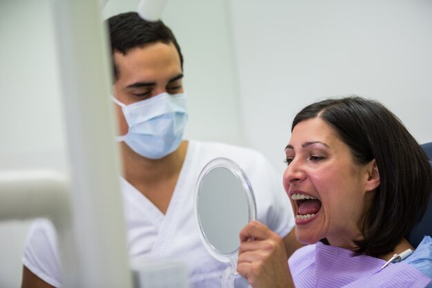 Dentist holding mirror in front of patient