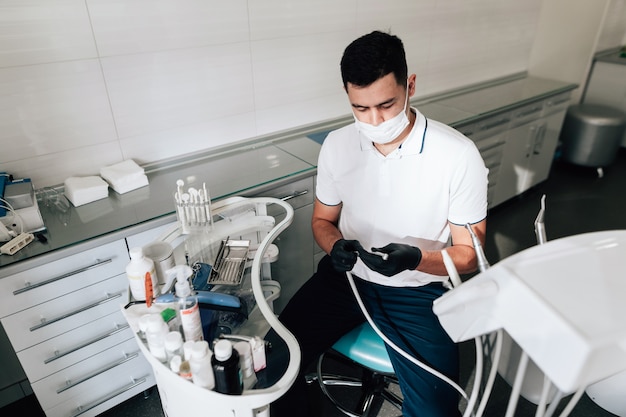 Dentist in office preparing surgical instruments