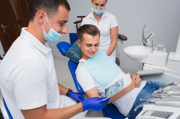 Dentist and patient smiling and looking at radiography