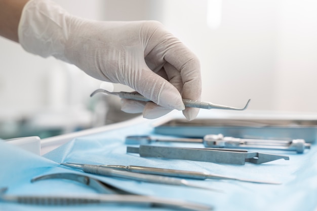 Dentist picking up utensil for teeth