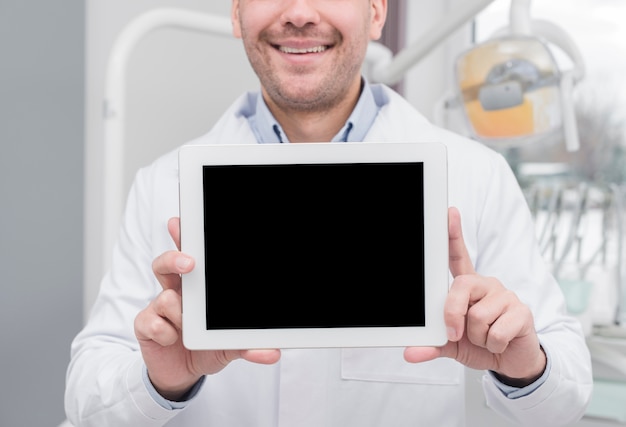 Free photo dentist presenting tablet