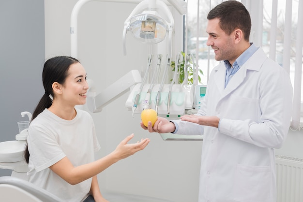 Dentist showing apple to patient