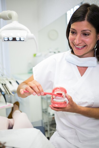 Dentist showing patient how to brush teeth