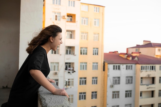 A depressed young girl crying and screaming at the balcony. High quality photo