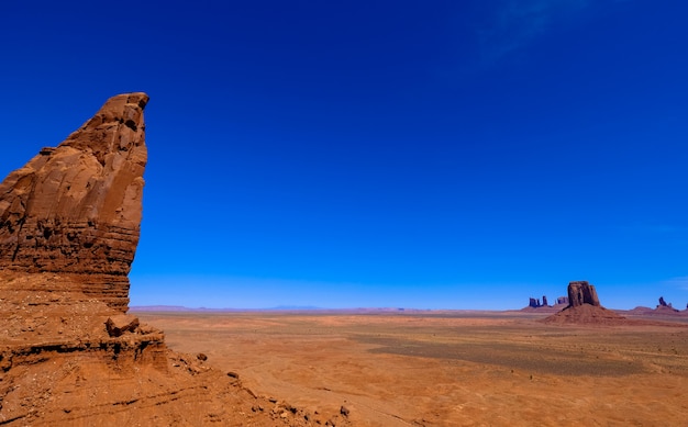 Free photo desert with cliffs and dry filed with clear blue sky