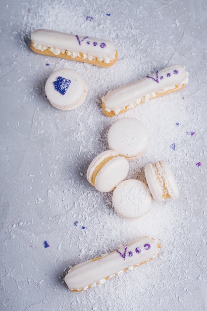 Free photo desiccated coconut over the baked macaroons and eclairs