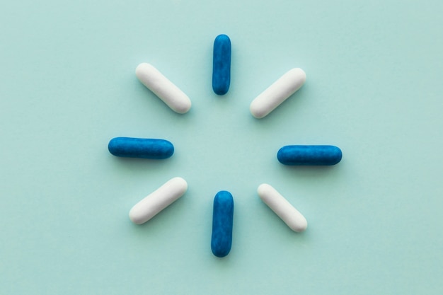 Design made with blue and white capsules on blank background