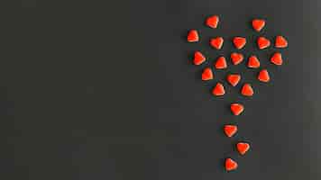 Free photo design made with heart shape candies on black background