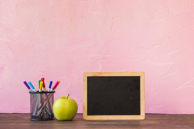 Free photo desk with chalkboard apple and pencil cup