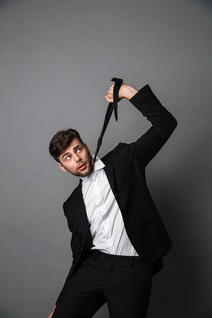 Free Photo desperate businessman strangling himself with a tie