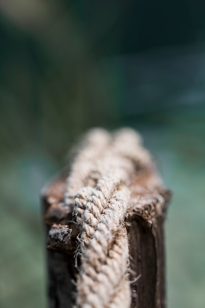 Free photo detail of an old frayed boat rope on wooden post