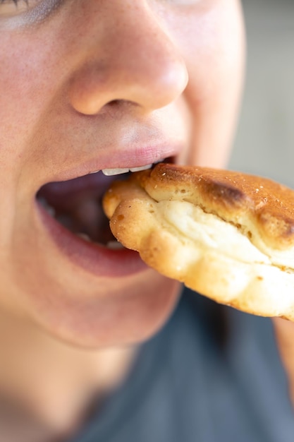 Free photo detailed shot of a woman eating fresh bun