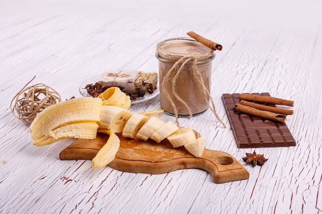 detox coctail with cinnamon sticks, bananas and chocolate lie on the table