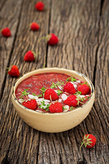 Detox and healthy superfoods breakfast in bowl. Vegan chia seeds pudding with strawberries and almond. Strawberries smoothie.