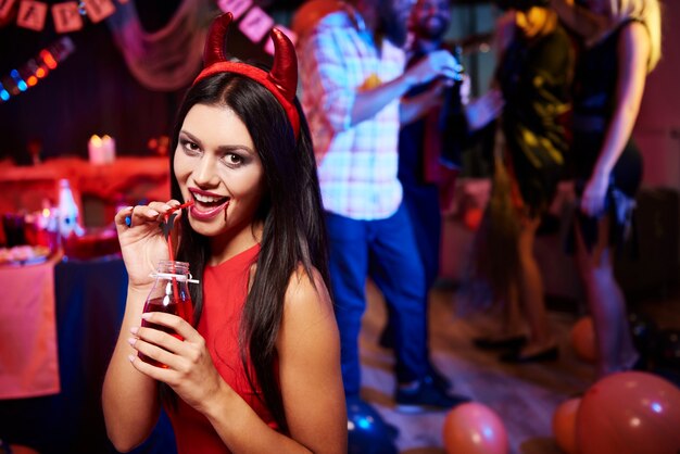 Devil lady posing at party drinking something