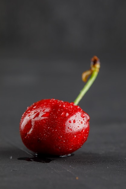 Free Photo dewy cherry side view on a grey table