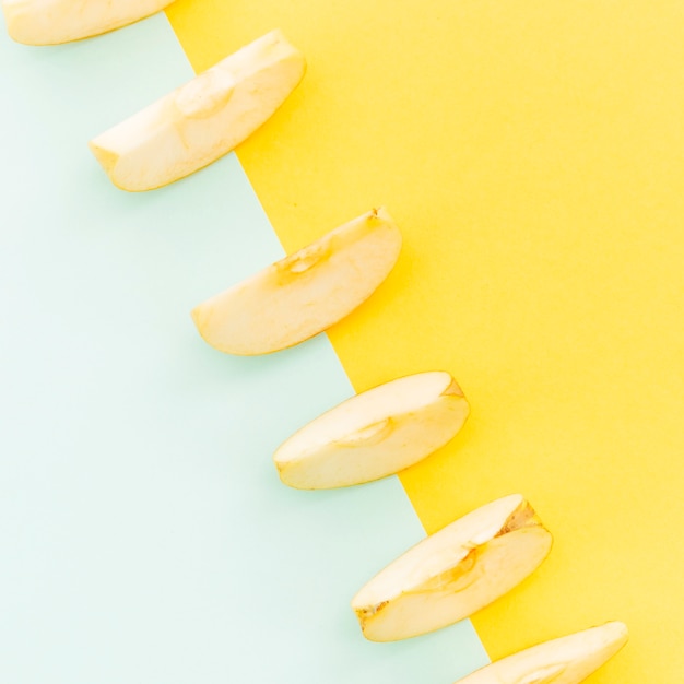 Free photo diagonal of apples slices on colorful background