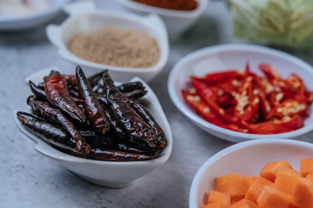 Free photo diced carrots, dried chilies, roasted rice, and chili paste on a cement floor.