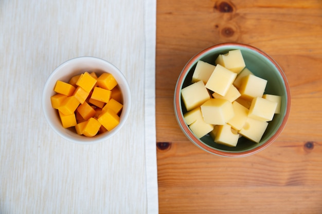 Free photo diced cheeses laying in ceramic bowls