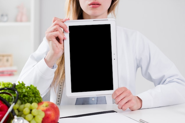 Free photo diet concept with female scientist showing tablet template