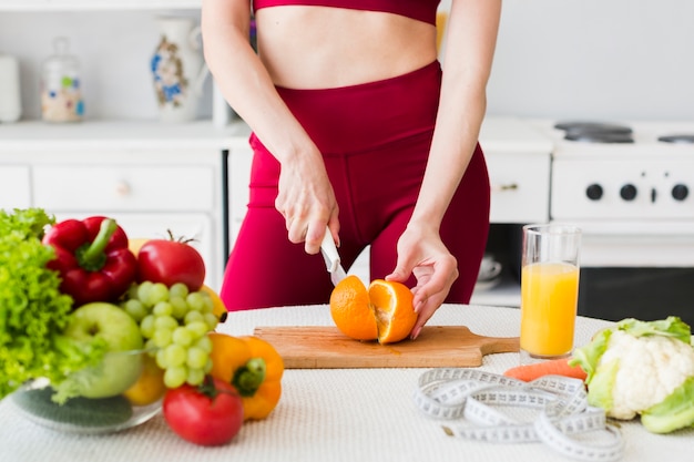 Free photo diet concept with sporty woman in kitchen