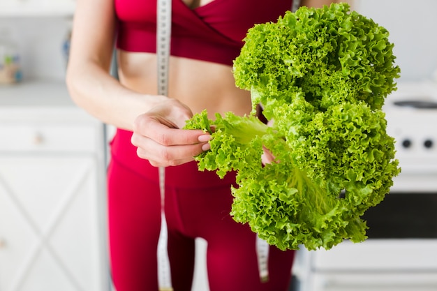 Free photo diet concept with sporty woman in kitchen