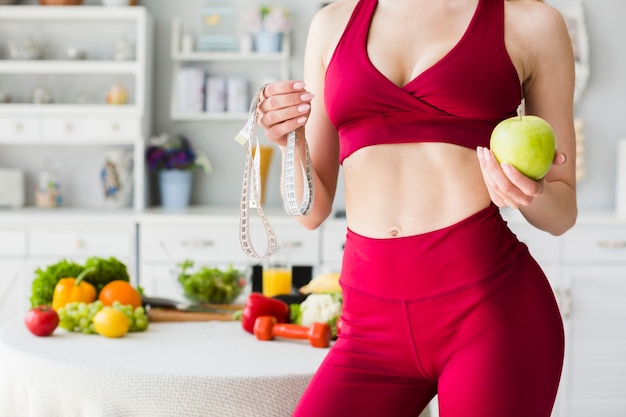 Free photo diet concept with sporty woman in kitchen