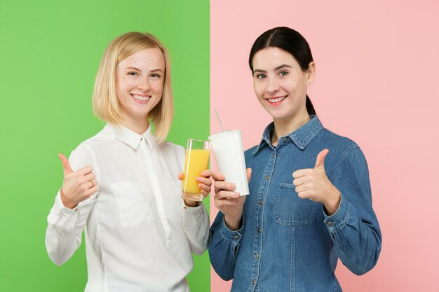 Diet. Dieting concept. Healthy Food. Beautiful Young Women choosing between fruit orange juice and unhelathy carbonated sweet drink