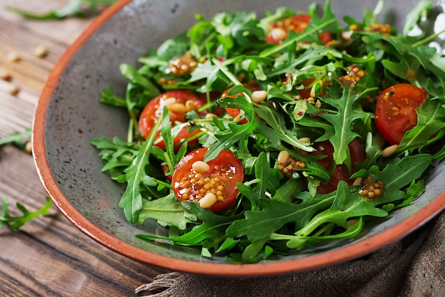 Free photo dietary menu. vegan cuisine. healthy salad with arugula, tomatoes and pine nuts.