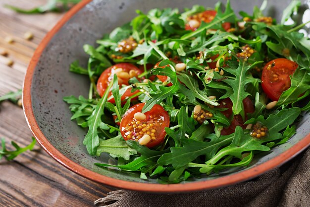 Dietary menu. Vegan cuisine. Healthy salad with arugula, tomatoes and pine nuts.