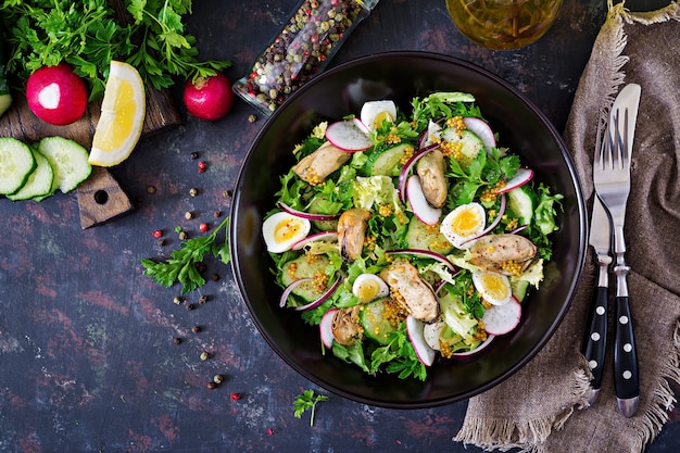 Dietary salad with mussels, quail eggs, cucumbers, radish and lettuce. Healthy food. Seafood salad. Top view. Flat lay.