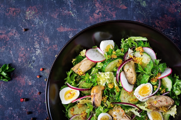 Free photo dietary salad with mussels, quail eggs, cucumbers, radish and lettuce. healthy food. seafood salad. top view. flat lay.