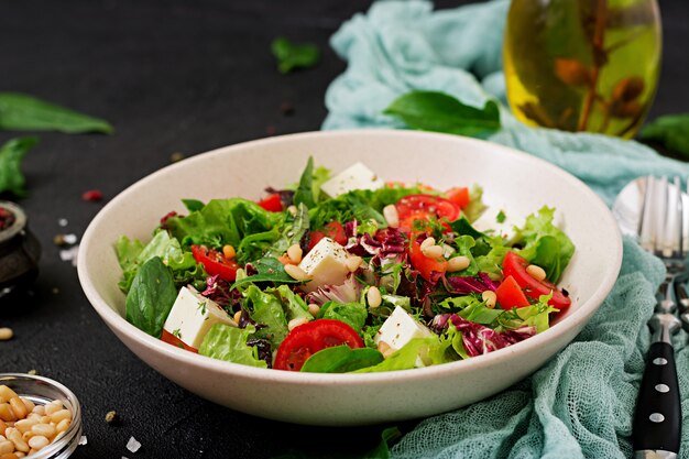 Dietary salad with tomatoes, feta, lettuce, spinach and pine nuts.