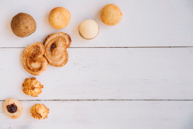 Different cookies scattered on wooden table