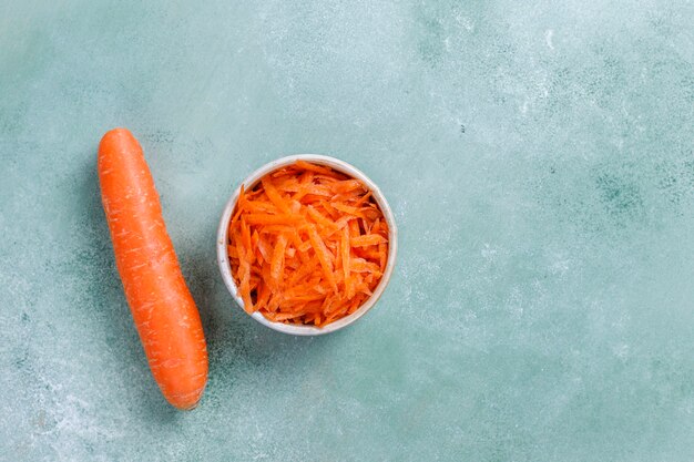 Different cuts of carrot in bowls.