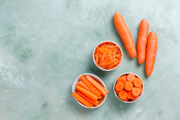 Free photo different cuts of carrot in bowls.