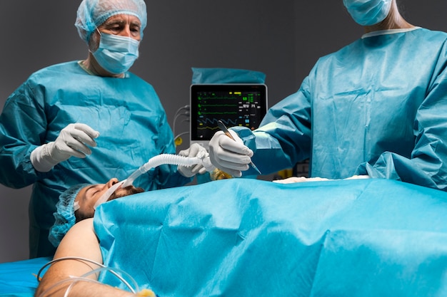 Free Photo different doctors doing a surgical procedure on a patient