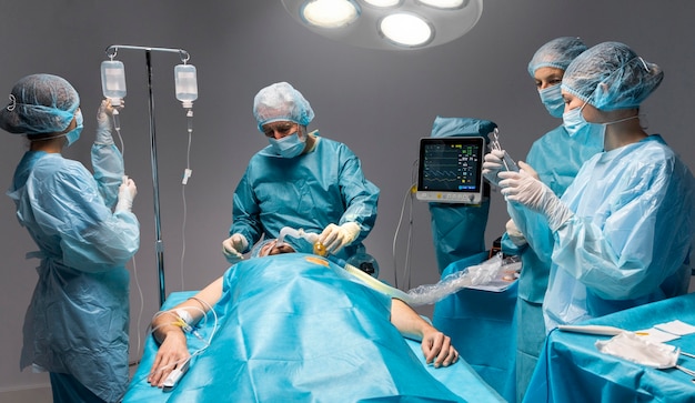 Different doctors doing a surgical procedure on a patient