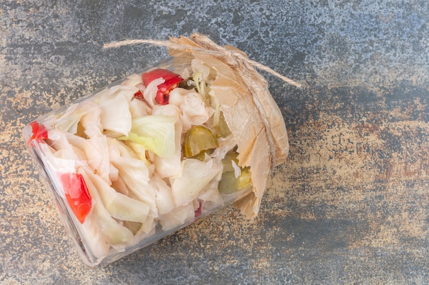 Free photo different fermented vegetables in a overturned jar.