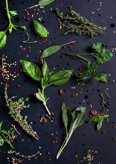 Free photo different herbs in black table, top view