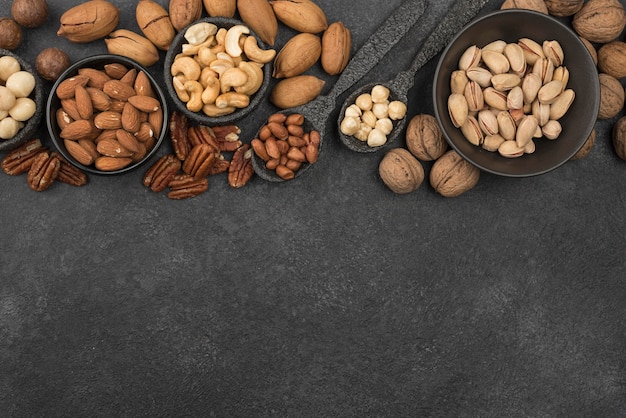 Free Photo different kinds of nuts on dark copy space background