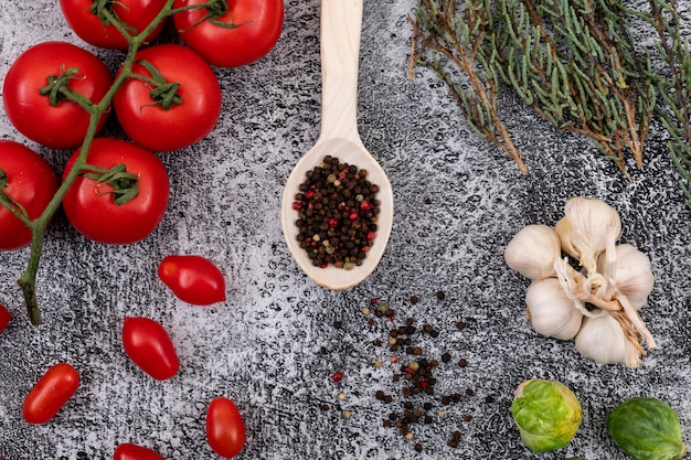 different kinds of vegetable with pepper on wood spoon on stone background